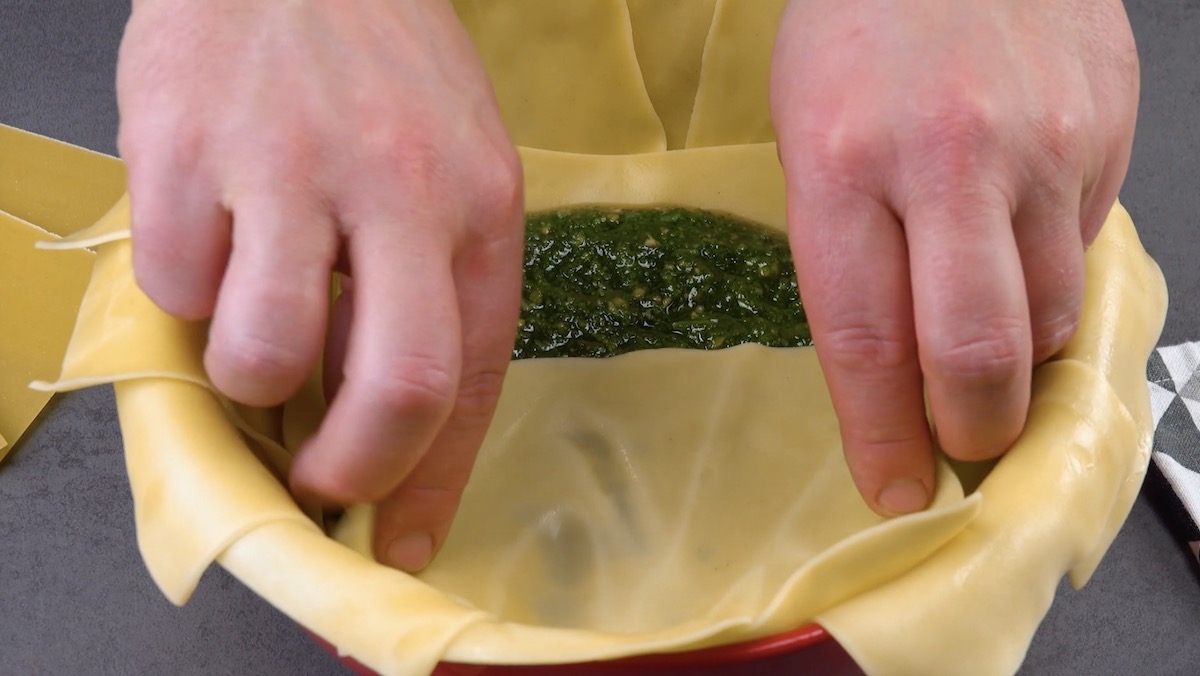 pesto de basilic sur des feuilles de lasagnes et moitié recouvert d'une feuille de lasagnes