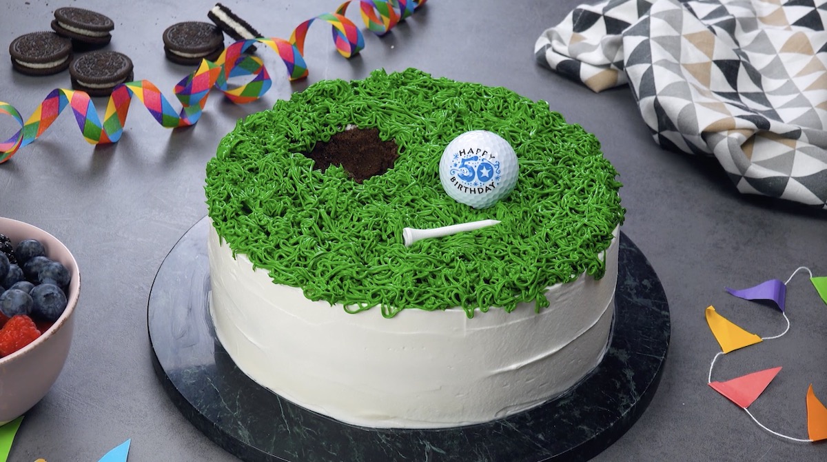 mettre du glaçage vert sur le gâteau et le décorer avec une balle de golf et un tee