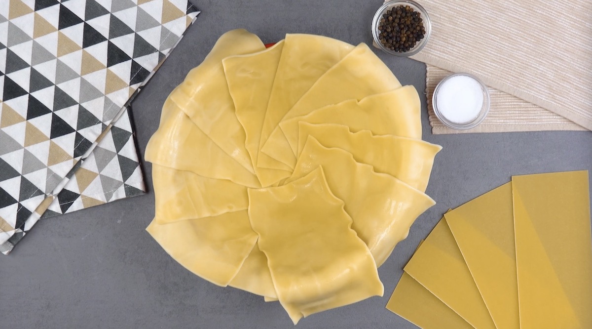 feuilles de lasagnes cuites déposées dans le fond et le bord d'un saladier allant au four